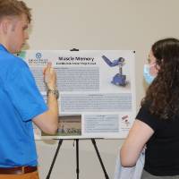 A student shares his poster presentation